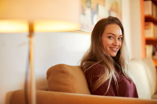 istock A woman sitting on a sofa and looking at the camera. 1323997419