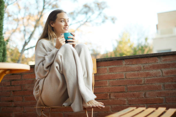 istock A beautiful woman drinking tea and relaxing on the terrace. 1323997540