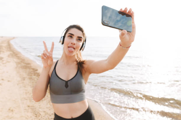 istock Playful young sportswoman standing at the beach 1323999734