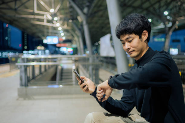 istock Businessman checking the time on his watch at train station 1324002149