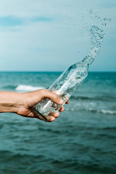 istock man pouring water out from a glass reusable bottle 1324002550