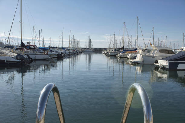istock pier with yachts and boats moored with blue sky background 1324003375