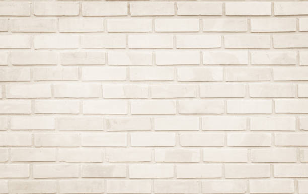 istock Empty Background of wide cream brick wall texture. Old brown brick wall concrete or stone pattern nature, wallpaper limestone abstract floor/Grid uneven interior rock. Home & office design backdrop. 1324003555