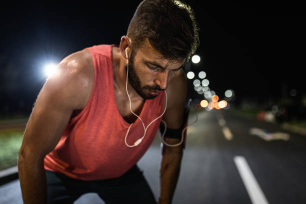 istock Male runner resting after night workout in the city. 1324003676