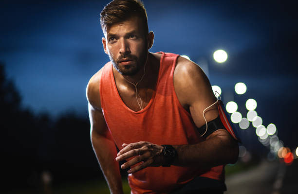 istock Man running through the city at night. 1324003677