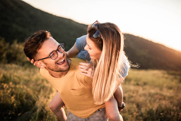 istock Young cheerful couple having fun while piggybacking in nature. 1324004878