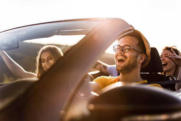 istock Young happy people going on a road trip by convertible car. 1324005869