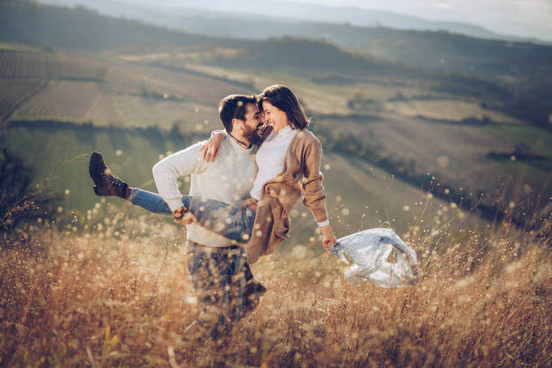 istock Young playful couple having fun in autumn day on a hill. 1324006884