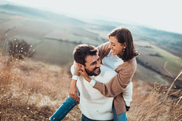 istock Young cheerful couple having fun while piggybacking on a hill. 1324007549