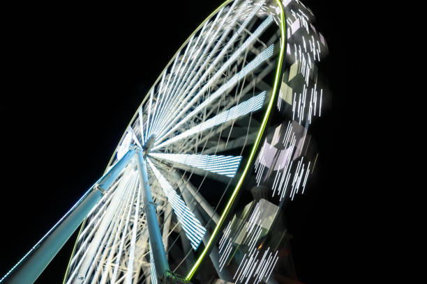 istock Beautiful glowing Ferris wheel against dark sky, motion blur effect 1324007622