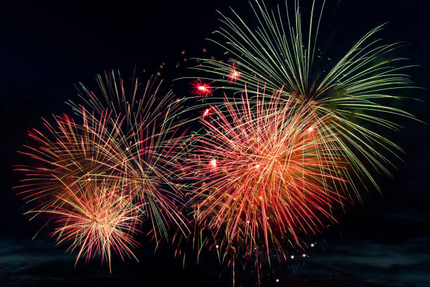 istock Bright colored fireworks on black background. Celebration and holidays concept. New Year, Independence Day, July 4 Festival. Bright explosions of lights in the sky. 1324009102