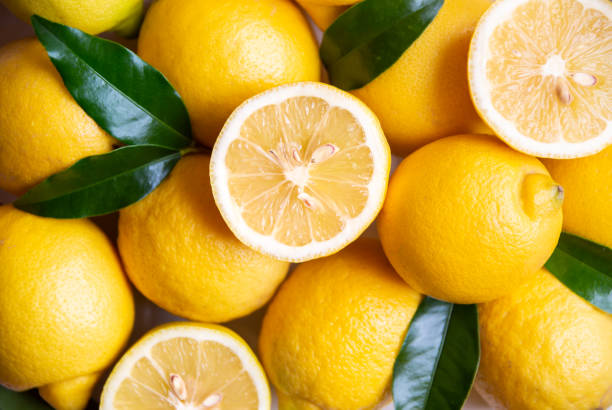 istock Fresh and ripe lemons with leaves on white wooden table 1324009362