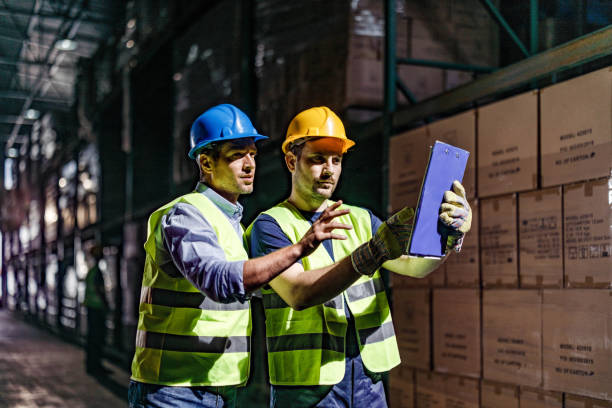 istock Warehouse worker and his manager going through checklist in a storage room. 1324009526