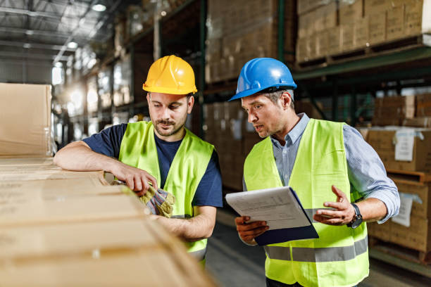 istock Manager giving instructions to his worker in distribution warehouse. 1324009669