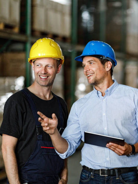 istock Happy foreman giving instructions to manual worker in distribution warehouse. 1324010918