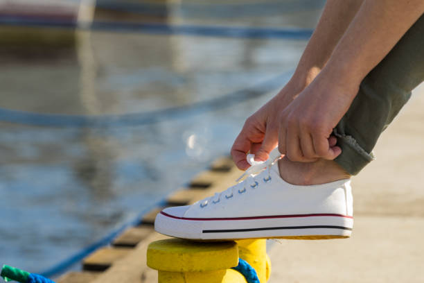 istock Woman tying shoes, white sneakers 1324012471