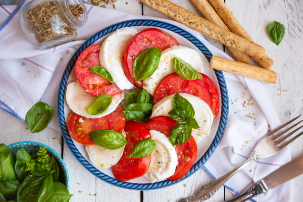 ensalada caprese con queso mozzarella, tomates y albahaca. cocina típica italiana - mozzarella caprese salad tomato italian cuisine fotografías e imágenes de stock