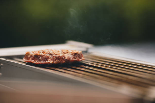 istock Cooking a beef hamburger patty on a grill.Copy-space. 1324014763