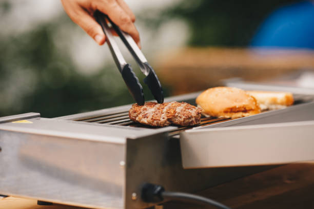 istock Cooking home burgers using electric grill. 1324014778