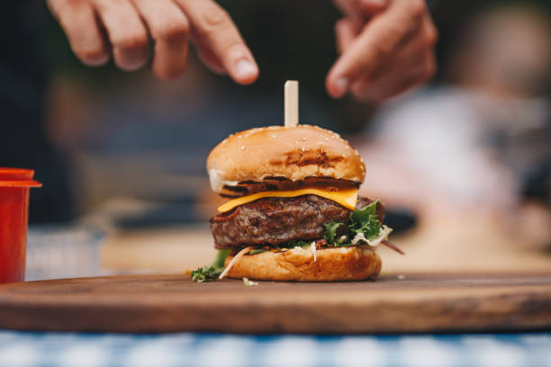 szef kuchni przygotowuje hamburgera. - cheeseburger zdjęcia i obrazy z banku zdjęć