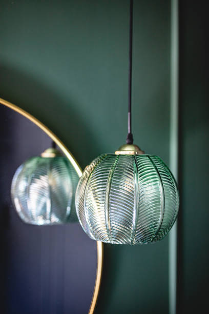 istock Elegant retro lamp hanging next to a mirror on dark green wall. 1324015484