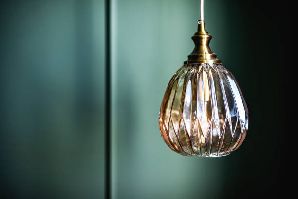 istock Elegant retro lamp hanging against dark green wall 1324015500