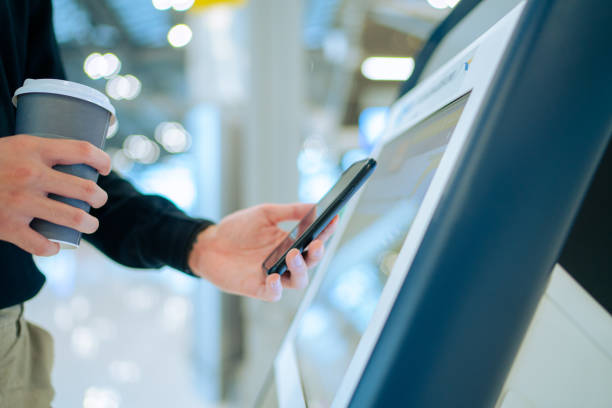 istock Young Asian man travelling by plane and doing self check in at the airport using a machine 1324016738