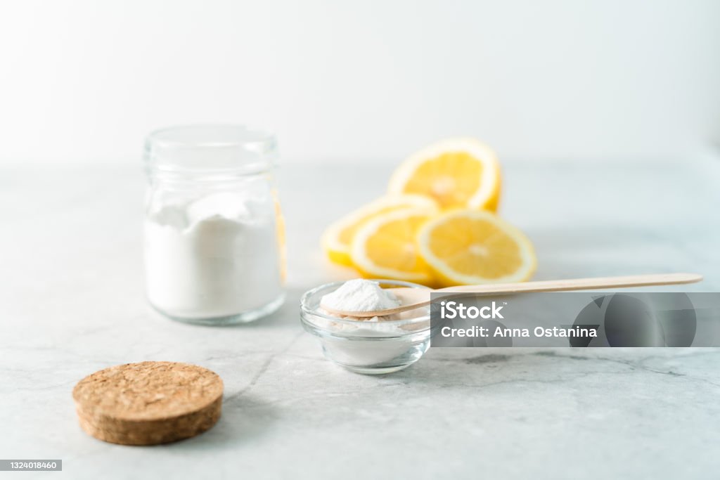 Eco friendly natural cleaners, jar with baking soda, lemon and wooden spoon on marble table background. Organic ingredients for homemade cleaning. Zero waste concept Eco friendly natural cleaners, jar with baking soda, lemon and wooden spoon on marble table background. Organic ingredients for homemade cleaning. Zero waste concept. Baking Soda Stock Photo