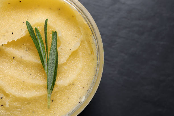 istock Body scrub and rosemary in jar on black table, top view. Space for text 1324020707