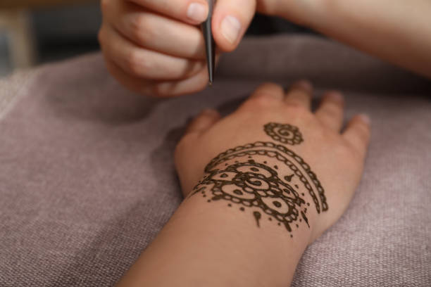 istock Master making henna tattoo on hand, closeup. Traditional mehndi 1324022054