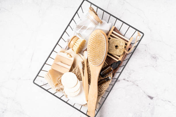 istock Basket with Natural bathroom and home spa tools. Zero waste concept. Bamboo toothbrush, natural soap bar, cotton pads, brush, homemade beauty products in reusable bottles on white marble background 1324022177
