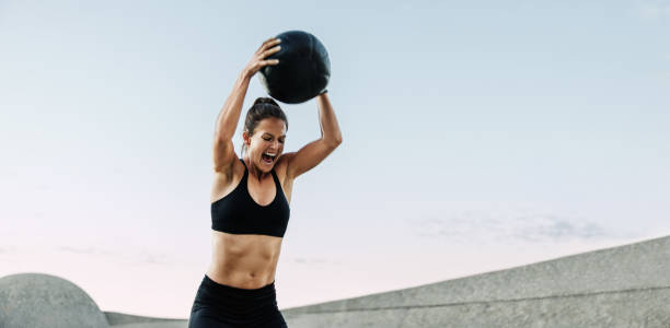istock Sportswoman doing intense workout with medicine ball 1324026965