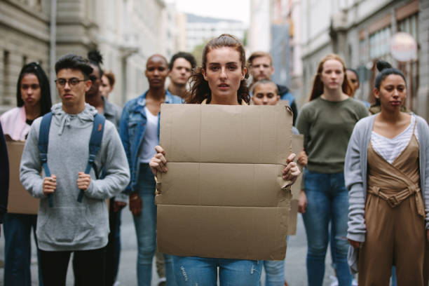 menschen, die auf der straße demonstrieren und schilder halten - nun sign holding women stock-fotos und bilder