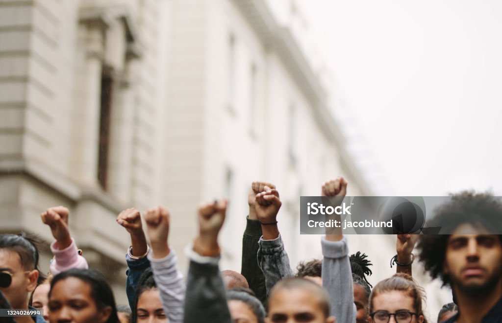 Arms raised in protest Arms raised in protest. Group of protestors fists raised up in the air. Protest Stock Photo