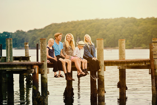 Family with three children sitting looking at their small boat