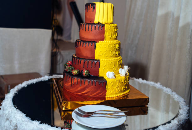 istock Round multi tiered  yellow and brown wedding cake with strawberries, roses and chocolate icing. Plate and fork near the cake 1324030979