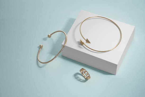 istock Modern design arrow shape and diamond bracelets and ring on white box on blue 1324031085