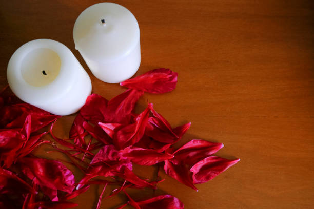 white candles and red floral petals on wooden furniture background. Top view. Copy space. SPA, hotel, romantic concept white candles and red floral petals on wooden furniture background. Top view. Copy space. SPA, hotel, romantic concept rose christmas red white stock pictures, royalty-free photos & images