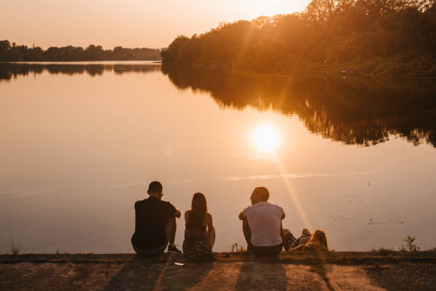 istock Friends watching a sunset over a like 1324035080