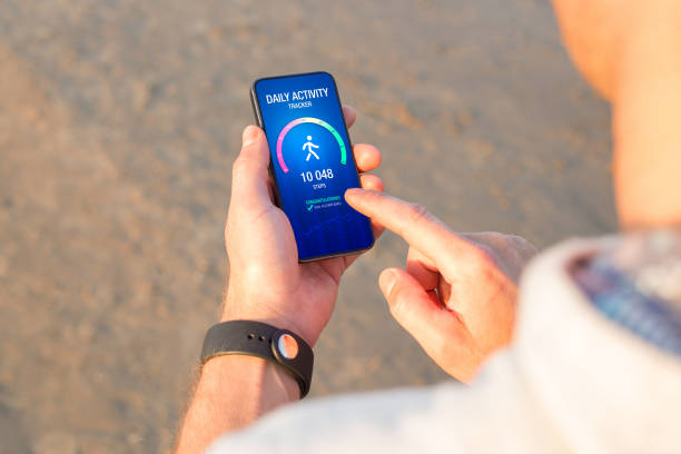 istock Man using daily activity tracking app on mobile phone showing 10 000 steps daily goal achievement 1324038732