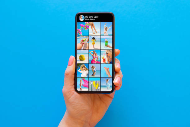 чья-то фотогалерея в социальных сетях показана на экране мобильного телефона на синем фоне - feed on стоковые фото и изображения