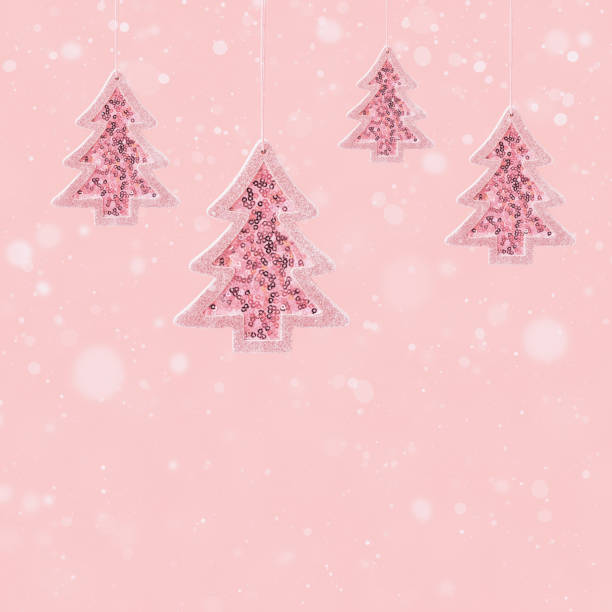 istock Hanging pink Christmas tree toys with silver shine sequins and falling snow, winter celebration concept 1324040680