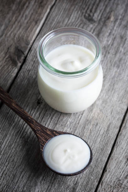 istock Yoghurt pot, wooden table background 1324040943