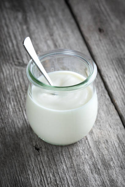 istock Yoghurt pot, wooden table background 1324040949