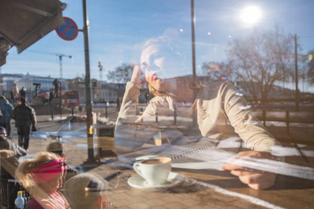 istock Young female student looking through window in coffee shop 1324042727