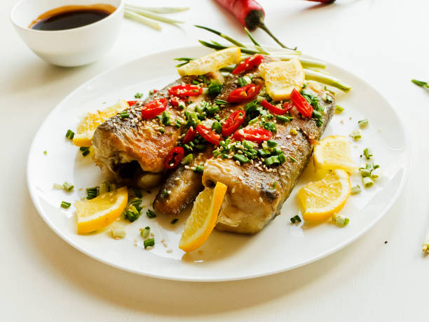 Hake fish Baked hake fish with herbs and spices, soy sauce. Shallow dof. hake stock pictures, royalty-free photos & images