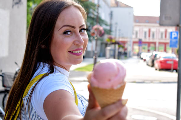 istock Woman outdoors holding ice cream 1324044577