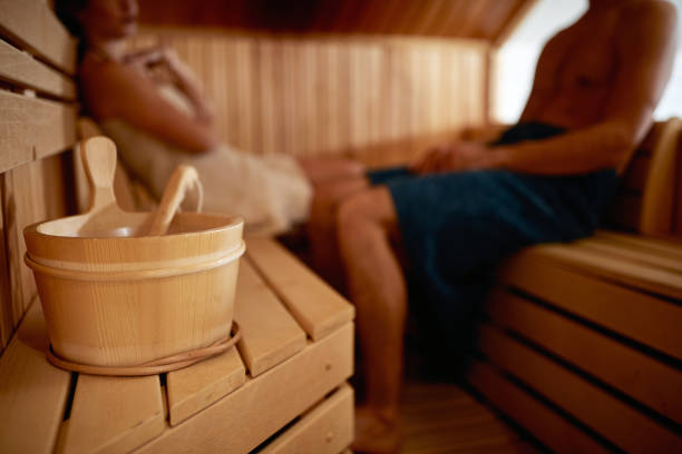 un jeune couple profitant du sauna. relation, loisirs, détente - sauna photos et images de collection