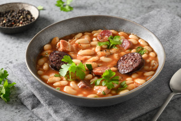 asturiana fabada espanhola com chorizo e morcilla em fundo cinza. - asturiana - fotografias e filmes do acervo