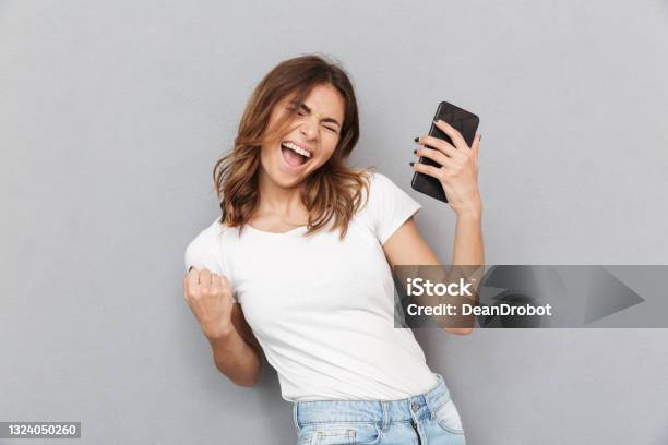Portrait Of A Satisfied Young Woman Stock Photo - Download Image Now - Happiness, People, Mobile Phone